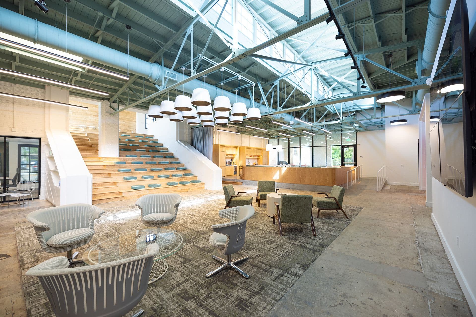 Open-concept meeting space with stadium seating and modern kitchen